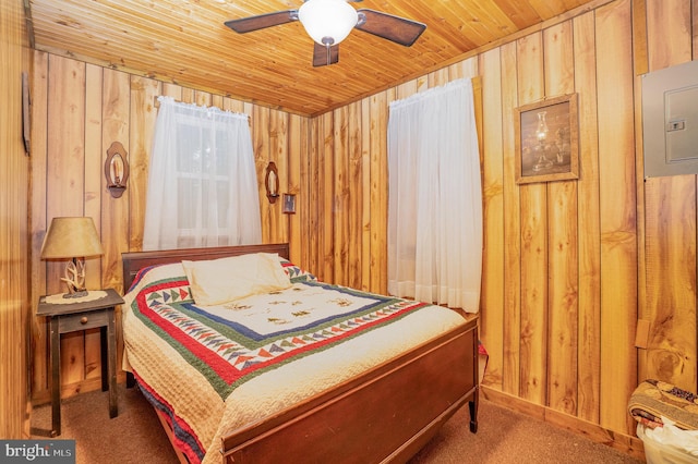 bedroom featuring ceiling fan, wooden ceiling, wood walls, and carpet floors