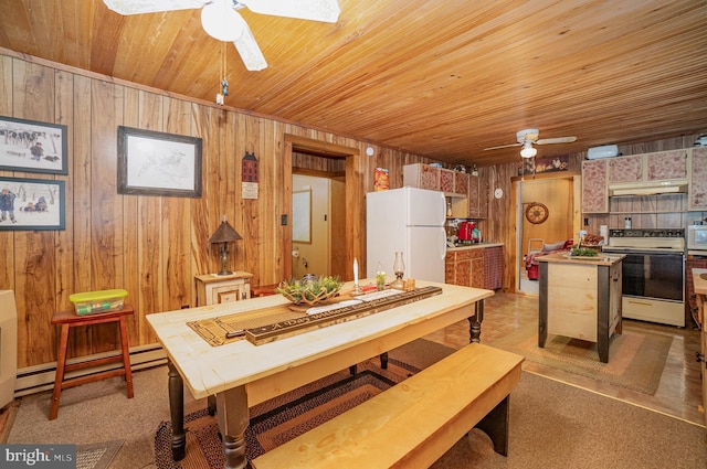 dining area featuring baseboard heating, ceiling fan, wood ceiling, and wooden walls