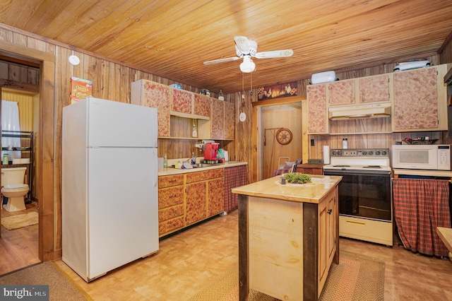 kitchen featuring white appliances, a center island, wood walls, ceiling fan, and wood ceiling