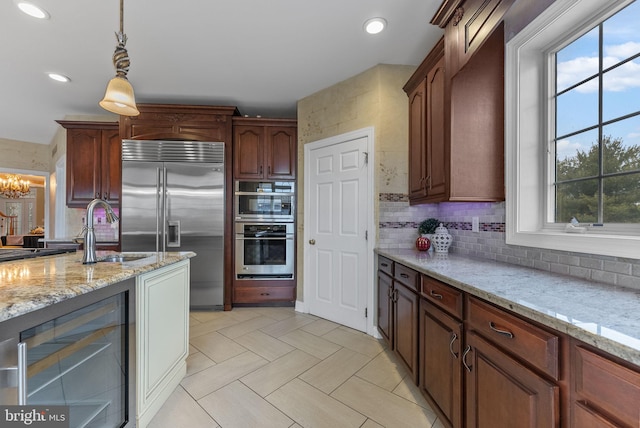 kitchen with decorative light fixtures, sink, wine cooler, decorative backsplash, and stainless steel appliances