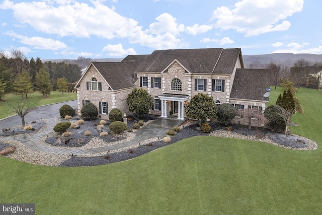 view of front facade featuring a mountain view and a front lawn