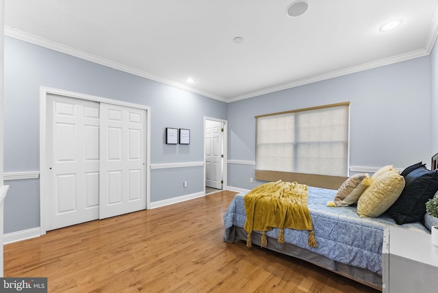 bedroom with crown molding, a closet, and light wood-type flooring