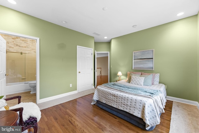 bedroom with hardwood / wood-style floors and ensuite bath