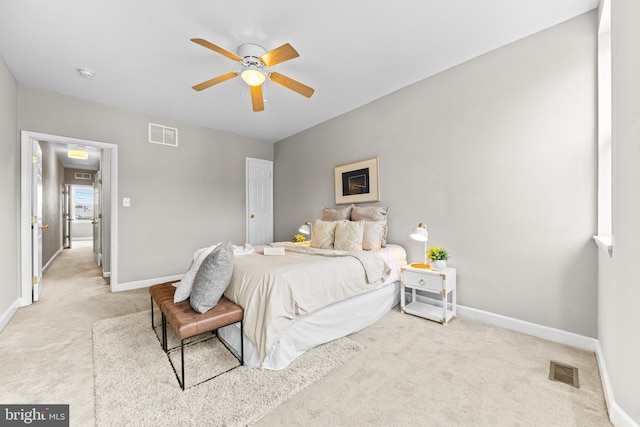 bedroom with visible vents, light carpet, and baseboards