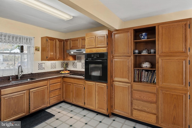 kitchen featuring open shelves, dark countertops, a sink, under cabinet range hood, and black appliances