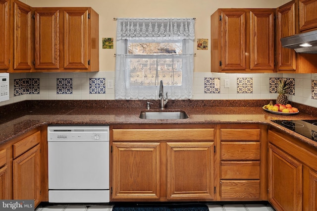 kitchen with white appliances, brown cabinetry, a sink, and under cabinet range hood