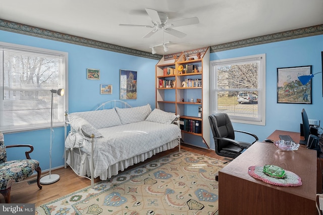 bedroom with light wood finished floors and a ceiling fan