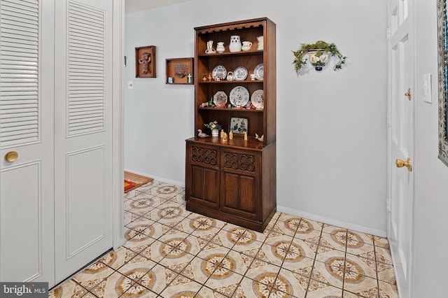 hallway featuring light tile patterned floors and baseboards