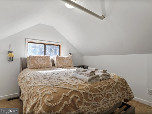 bedroom with vaulted ceiling, carpet floors, visible vents, and baseboards