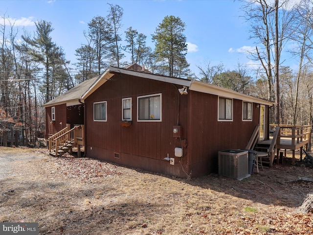 view of side of home with a shingled roof, crawl space, and cooling unit