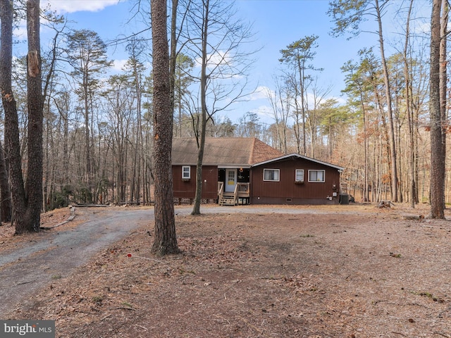 view of front of house featuring crawl space, a shingled roof, dirt driveway, and central AC