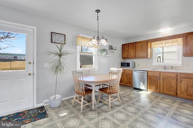 kitchen featuring sink, appliances with stainless steel finishes, a chandelier, and pendant lighting