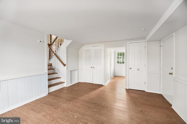 interior space with stairs, wainscoting, and wood finished floors