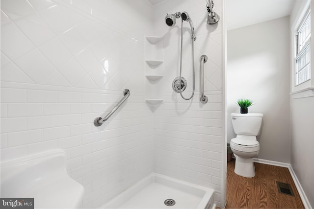 full bath featuring visible vents, toilet, a shower stall, wood finished floors, and baseboards