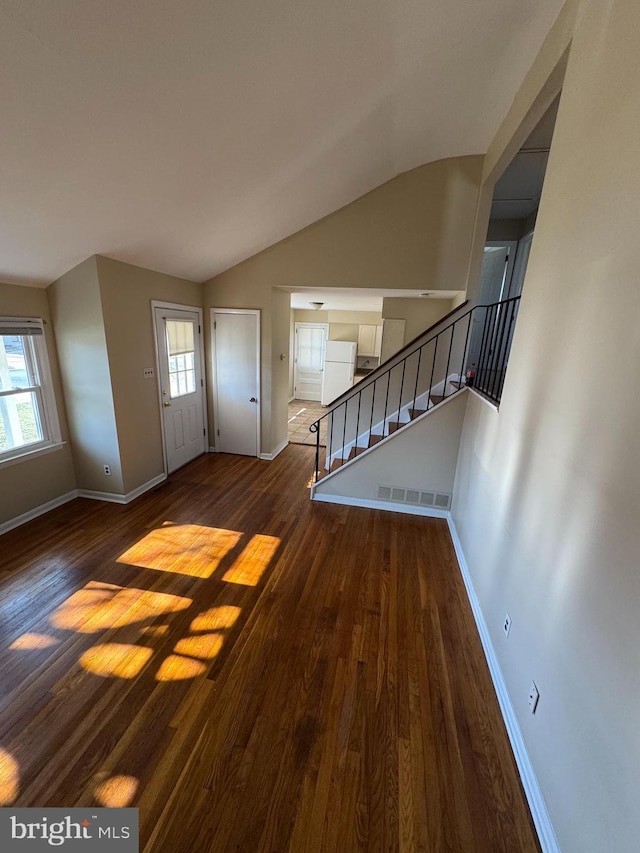 foyer entrance with a wealth of natural light, stairway, and wood finished floors