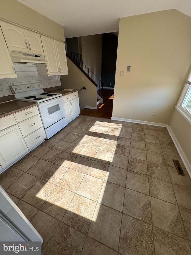 kitchen featuring dark countertops, white electric range, visible vents, white cabinets, and under cabinet range hood