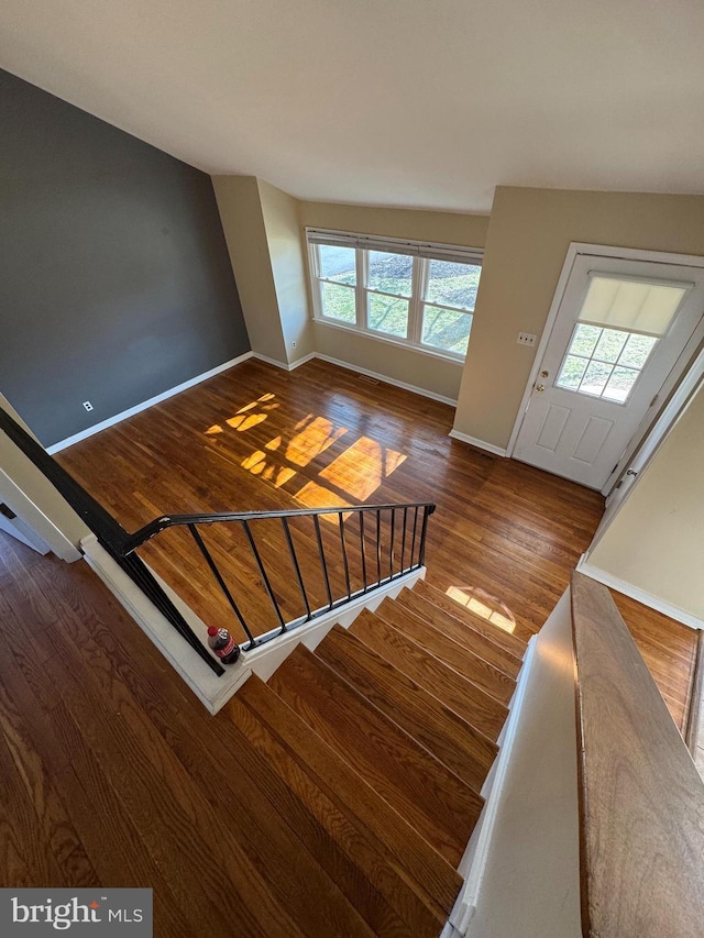 stairway with wood finished floors and baseboards