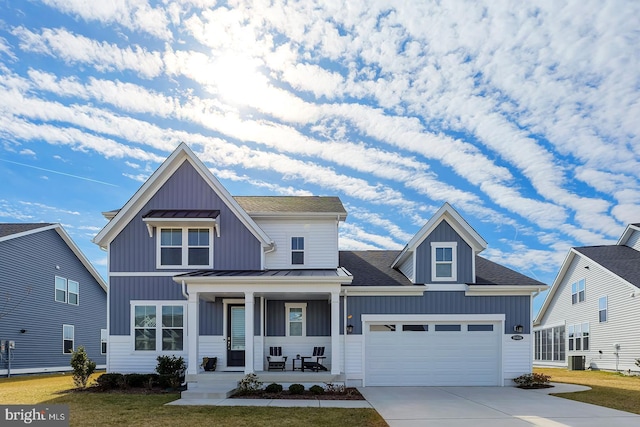 view of front of property featuring board and batten siding, covered porch, a standing seam roof, and concrete driveway