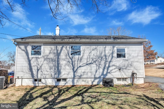 exterior space with central AC and a lawn