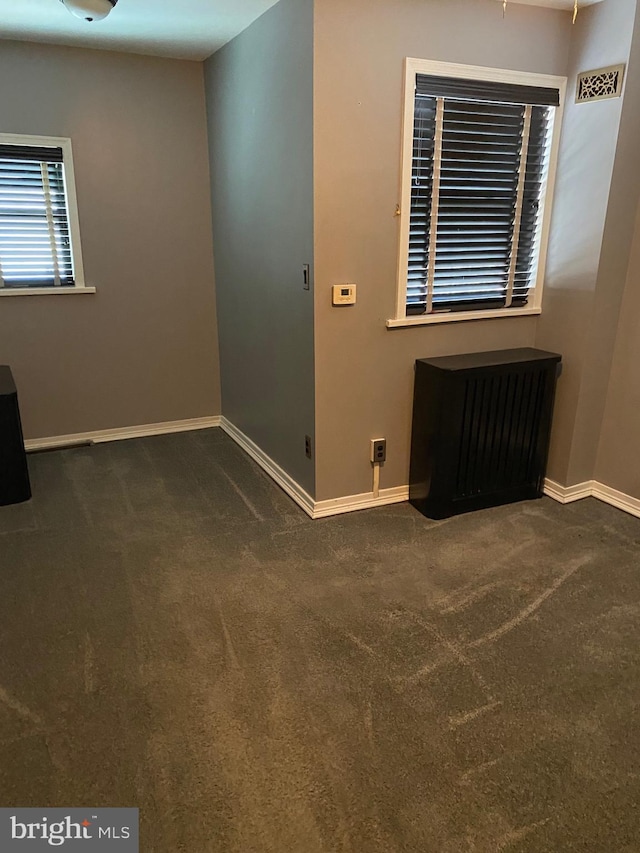 spare room featuring dark colored carpet