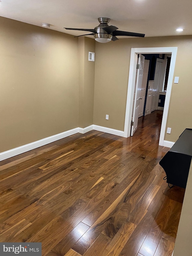 spare room with dark hardwood / wood-style flooring and ceiling fan