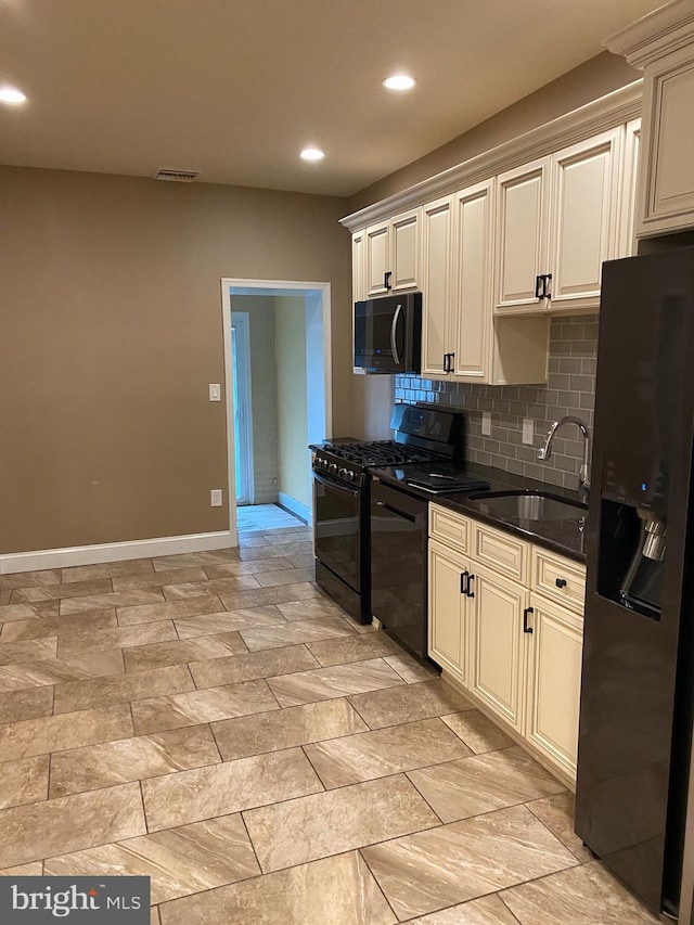 kitchen with tasteful backsplash, sink, dark stone countertops, and black appliances