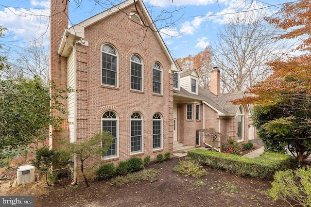 view of front of house with brick siding and a chimney