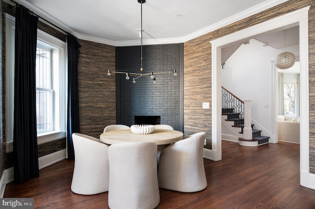 dining room with baseboards, wood finished floors, stairs, and ornamental molding