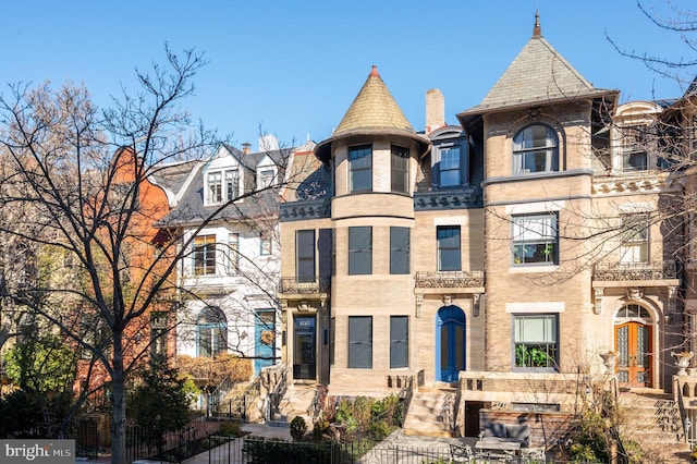 view of front facade featuring a fenced front yard and a high end roof