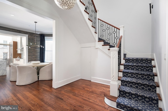 staircase featuring baseboards and wood finished floors