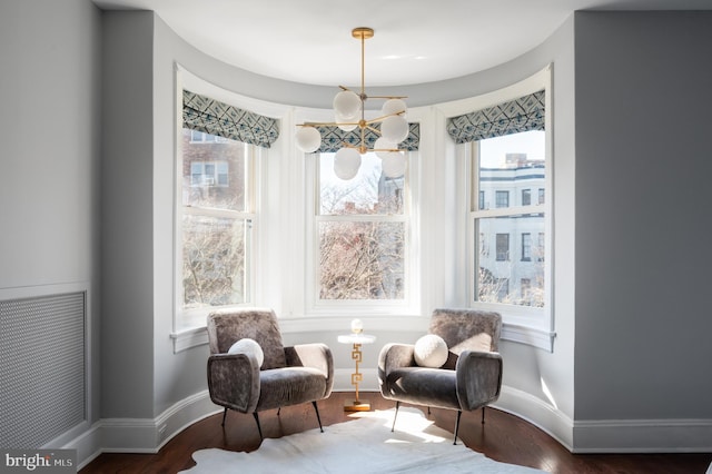 sitting room featuring a chandelier, visible vents, baseboards, and wood finished floors