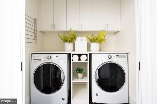 washroom with cabinet space and washing machine and clothes dryer