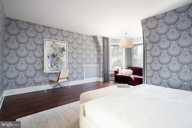 bedroom featuring visible vents, baseboards, wood finished floors, and wallpapered walls