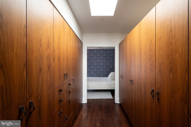 corridor with dark wood-style floors and a skylight