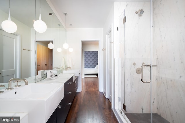 ensuite bathroom with a marble finish shower, vanity, wood finished floors, and ensuite bathroom