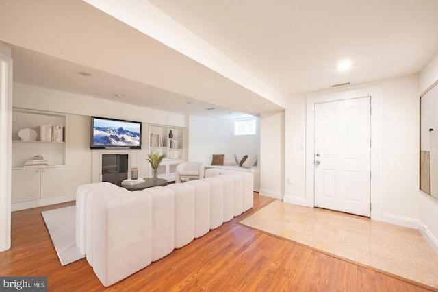 living area featuring visible vents, wood finished floors, and baseboards