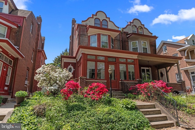 victorian home featuring brick siding