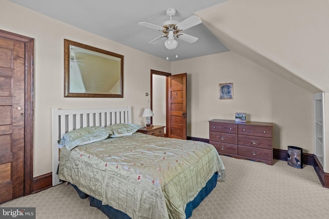 carpeted bedroom with vaulted ceiling, baseboards, and a ceiling fan