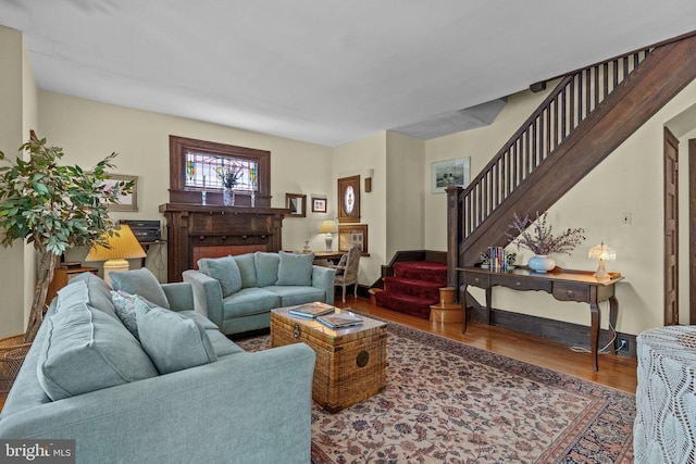 living room with baseboards, stairway, and wood finished floors