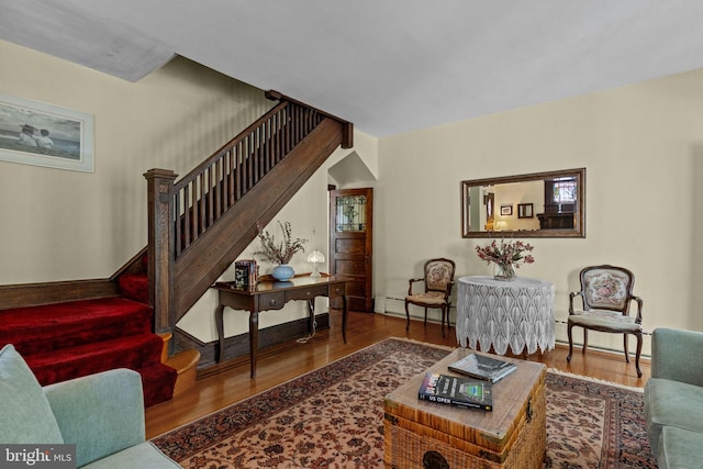 living area with stairs and wood finished floors
