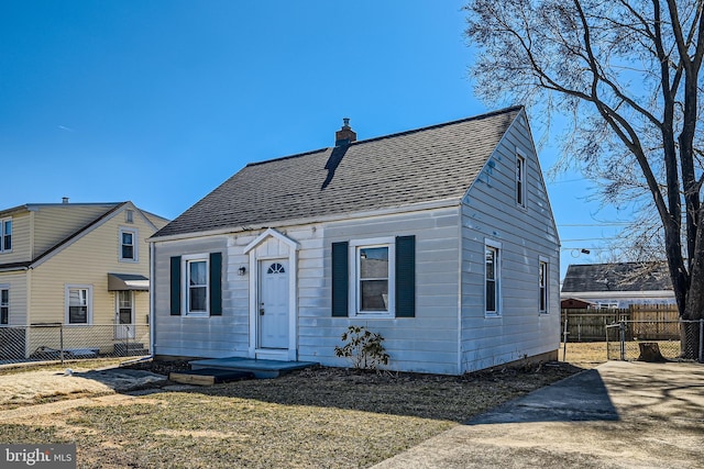 view of front of property featuring roof with shingles, fence, a chimney, and a front lawn