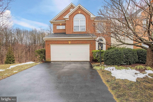 view of front facade featuring driveway, brick siding, an attached garage, and a shingled roof