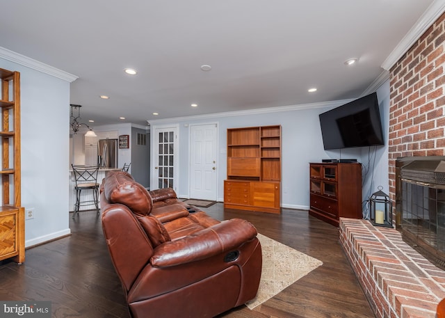 living area with baseboards, dark wood-style flooring, a fireplace, and crown molding