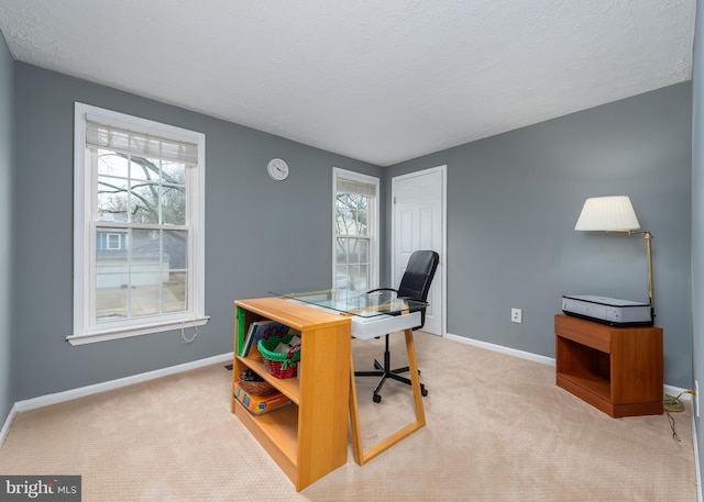 carpeted home office featuring baseboards and a textured ceiling