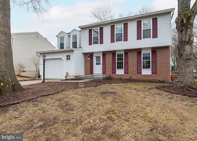 colonial-style house featuring a garage, brick siding, and driveway