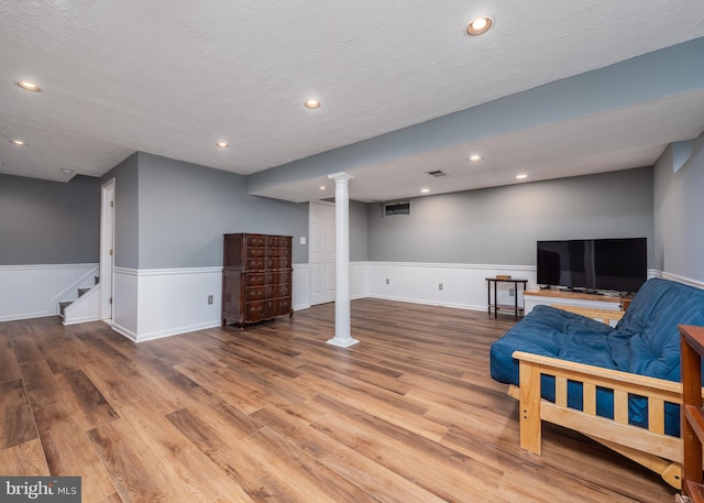 sitting room with recessed lighting, a wainscoted wall, a textured ceiling, and wood finished floors