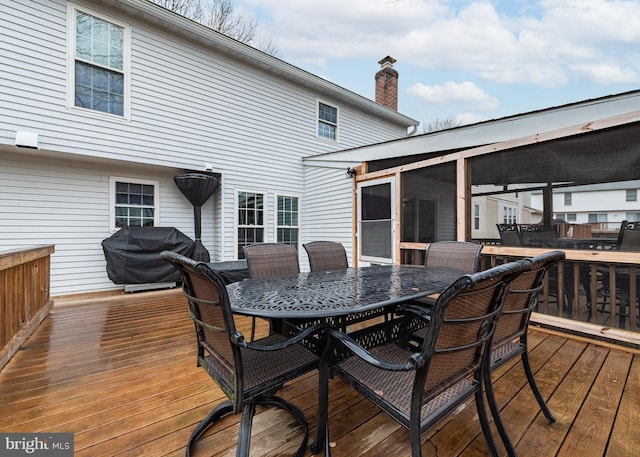 deck featuring outdoor dining area and grilling area