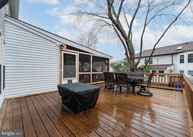 deck featuring outdoor dining space and a sunroom