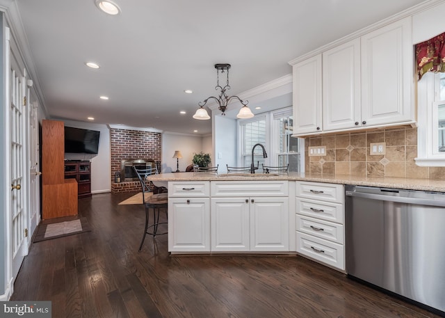 kitchen featuring dishwasher, ornamental molding, open floor plan, a peninsula, and a sink