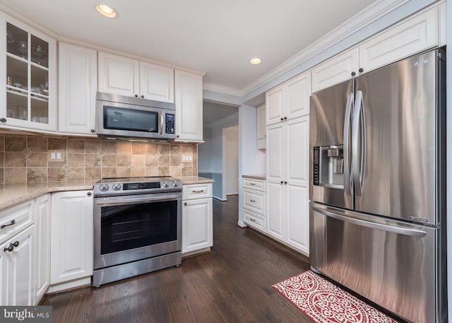 kitchen with stainless steel appliances, white cabinets, light stone countertops, glass insert cabinets, and crown molding